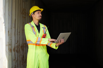 worker or engineer working on laptop computer in containers warehouse storage
