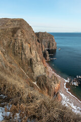 Mystical high cliffs rise above the sea. Harsh winter seascape. Place of power, calm of the...