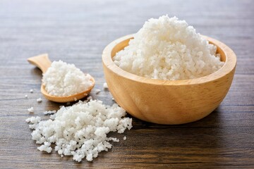 sea ​​salt in a wooden bowl with wooden spoon on cement background