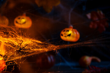 Halloween. spider crawls on the web. Garland with orange pumpkins