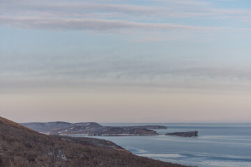 Obraz premium Mystical high cliffs rise above the sea. Harsh winter seascape. Place of power, calm of the elements.