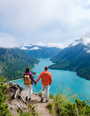 Fototapeta premium Couple admiring breathtaking views of Lake Plansee in Austria during a clear summer day