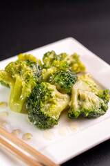 Broccoli on a white plate on a black background.food concept.diet.