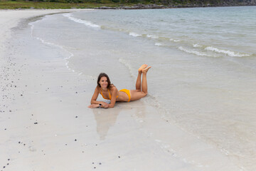 Woman, enjoying Ersfjord Beach on Senja island, beautiful landscape view over the mountains in Norway