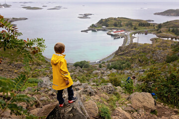 Fototapeta premium Children and adults, happy family with dog, climbing Festvagtinden via Heiavatnet trail in Norway