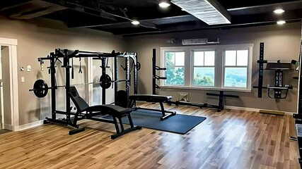a home gym with a bench, weight rack, and a window