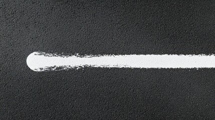 Fototapeta premium White paint streak on dark road with rough texture, ideal for copy space