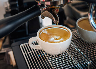 Close-up of espresso pouring from the coffee machine into a coffee cup. Professional coffee brewing
