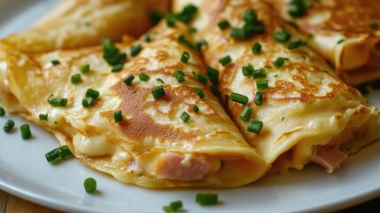 Close-up of spicy ham and cheese crepes with fresh chives on a white plate, showcasing a delectable and flavorful dish.