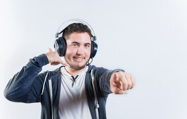 Young telemarker making call gesture on isolated background. Guy with headphones making a call me gesture isolated