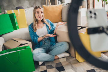 Photo of blonde hair lifestyle blogger woman sitting carpet in living room recording video using...