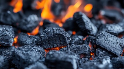 A detailed close-up of glowing charcoal briquettes, showcasing their rugged texture and the fierce flames engulfing them, creating a warm and energetic ambiance.