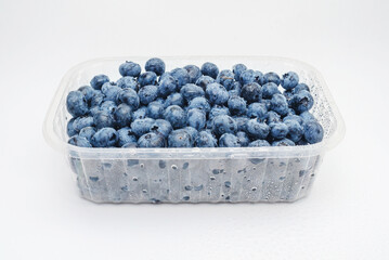 Transparent box with fresh blueberries isolated on white. Side view. Antioxidants, vitamins, health.
