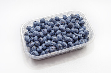 Top view transparent box with fresh blueberries isolated on white. Antioxidants, vitamins, health.