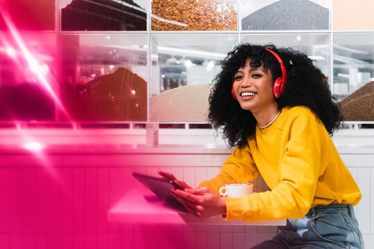 Beautiful woman using digital tablet at cafe looking at camera