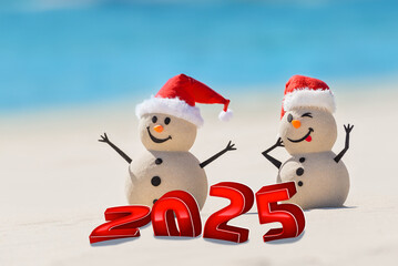 A funny greeting card featuring a cheerful sandy snowmen on a beautiful white sand beach.  3D numbers for the New Year stand in the sand.