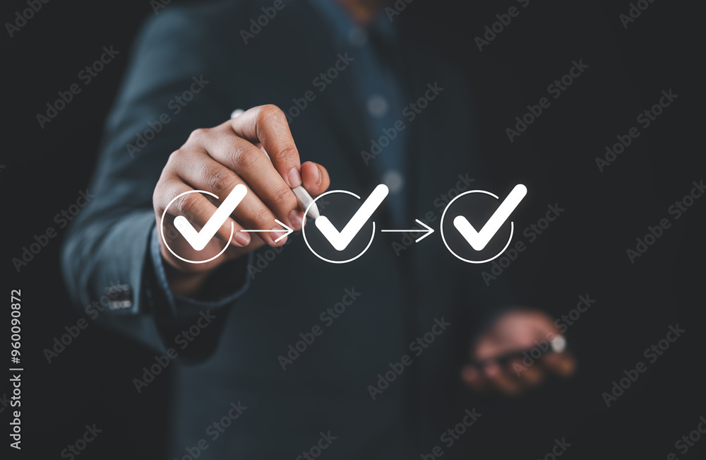 Fototapete Businessman writing to tick correct mark in checklist with progressive loading status to remind work task progressive for project develop management and tracking concept.