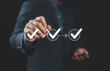 Businessman writing to tick correct mark in checklist with progressive loading status to remind...