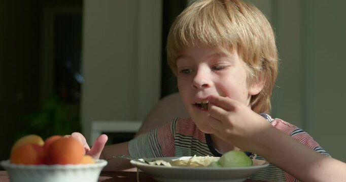 Cute Kid Boy Eat Spaghetti with Cucumber Vegetarian Food For Breakfast or Dinner. Slow motion 60 fps 4K 10-bit