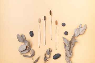 Natural eco wooden bamboo toothbrushes and natural stones on beige background. Dental care,...