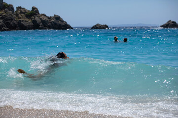 Woman swimming in waves, enjoying a wonderful swim in transparent turquoise waters