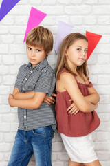 Boy and girl posing by the brick wall