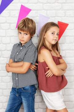 Boy and girl posing by the brick wall