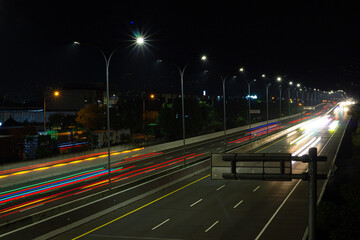 Fototapeta premium Night view of the highway. Photo with panning technique using low shutter speed.
