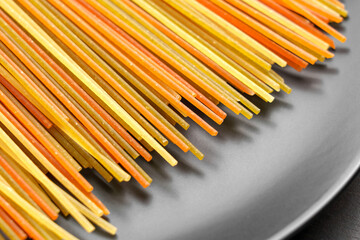 Uncooked pasta spaghetti, featuring striking colors derived from natural ingredients, elegantly...
