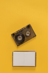 Retro audio cassette tape with empty playlist over yellow background. Empty audio cassette with a...