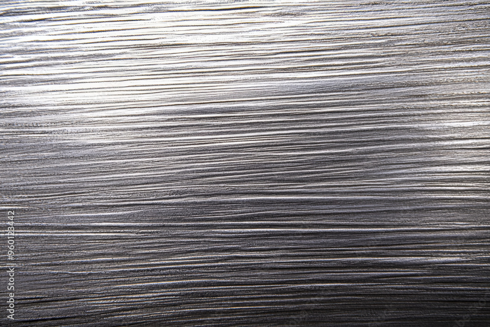 Poster a silver textured surface with a soft, brushed finish, showcasing fine, parallel lines that add a so