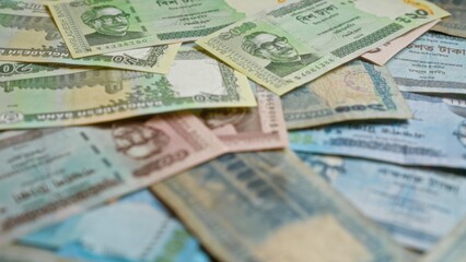 Bangladeshi taka banknotes displayed in a scattered arrangement highlighting the diverse currency...