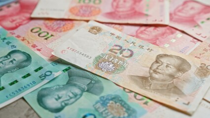 Chinese yuan banknotes scattered closely depict the colorful currency of china for financial and economic themes.