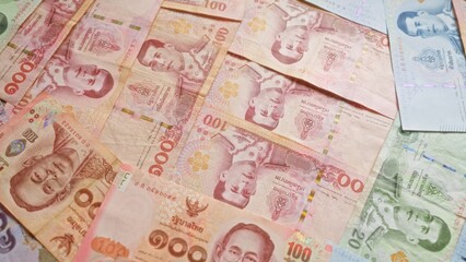 Thai banknotes scattered showcasing currency from thailand with intricate designs and various denominations prominently displayed.