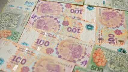 Argentinian banknotes of various denominations spread out, showcasing the vibrant designs and cultural imagery of the country's currency.