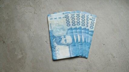 Chilean banknotes of ten thousand pesos spread out on a concrete surface, showcasing currency from...