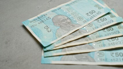 Indian banknotes of fifty rupees displayed on a concrete surface, emphasizing currency, finance, and the indian economy.