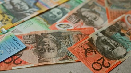 Australian banknotes scattered on a flat surface, showcasing vibrant colors and distinct designs depicting various denominations of australian dollars.
