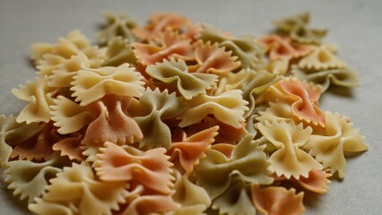 Closeup of colorful farfalle pasta on a concrete surface highlighting texture and variety.