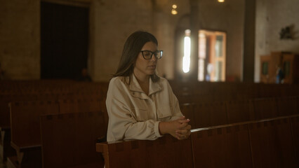 Young hispanic woman praying in a serene italian church environment, highlighting her beauty and...