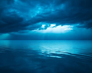 Obraz premium A serene ocean view under dramatic blue clouds, capturing the beauty of calm water and moody skies.