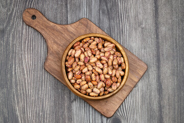 red kidney beans in wooden bowl isolated on dark background.