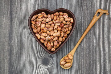 red kidney beans in wooden bowl isolated on dark background.