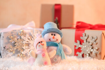 Funny snowman figures and gifts on artificial snow