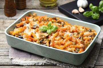 Delicious al forno pasta in baking dish on wooden table, closeup