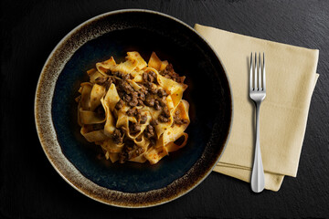 Dark bowl with pappardelle with wild boar ragout sauce