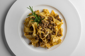 Plate with pappardelle with wild boar ragout sauce and rosemary