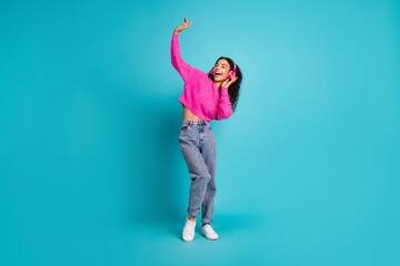 Full body photo of attractive teen girl dance headphones enjoy music dressed stylish pink clothes isolated on aquamarine color background © deagreez