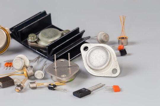 Old transistors various purpose in different packages on gray surface