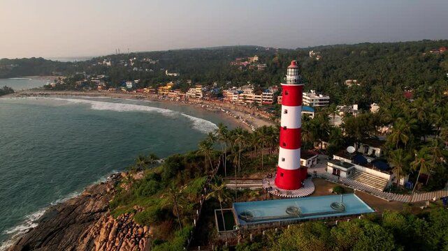 Lighthouse on the sea coastline at sunset, aerial view. Kovalam Beach whith Lighthouse in India, Kerala.